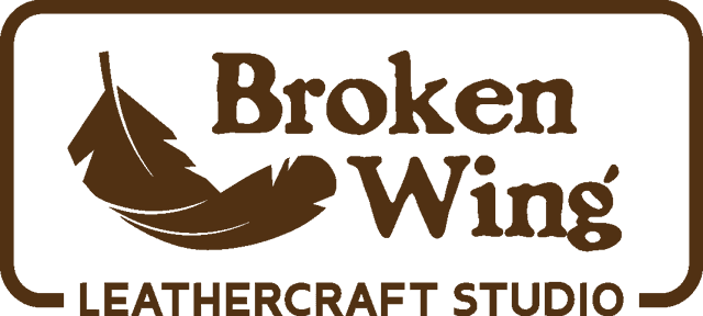 The header banner shows the rectangular "Broken Wing Leathercraft Studio" logo in the centre in a dark earthy brown on a hessian brown background. 
On the left hand side there are three text buttons labeled "Home", "Products", and "About Us".
On the right there is a magnifying glass icon, and a shopping basket icon.